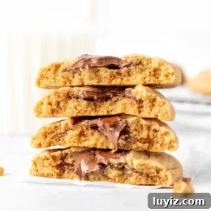Peanut Butter and Nutella Cookie Recipe: Gooey Chocolate Swirl Cookies 7 peanut butter Nutella cookies broken in half, with halves stacked one on top of another