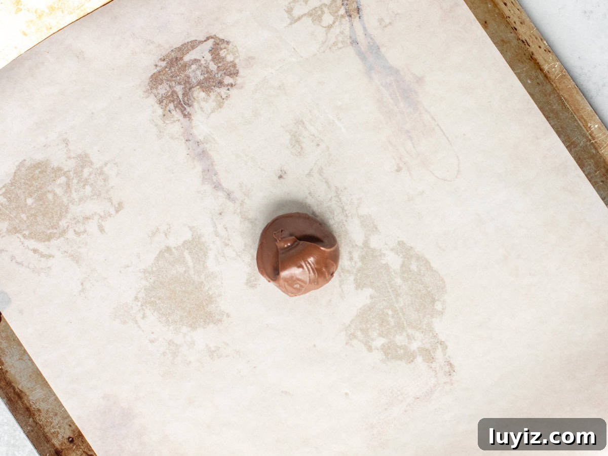 Nutella-Stuffed Single-Serve Chocolate Chip Cookie Recipe 4 Dollop of Nutella on a lined cookie sheet