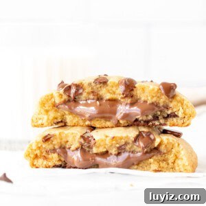 Single serving chocolate chip cookie stuffed with Nutella, broken in half with cookie halves placed on top of each other