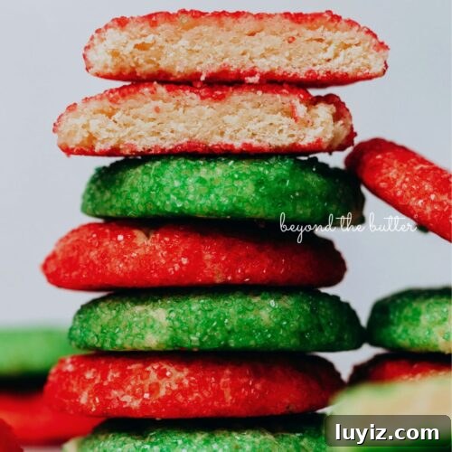 Stack of red and green sugared almond sprinkle cookies on a white background.