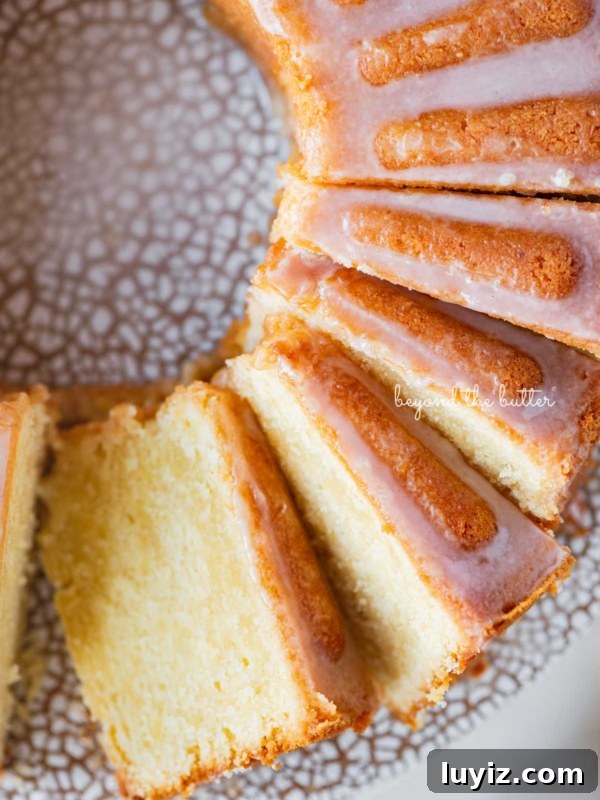 Lemon Cream Pie Recipe: Silky No-Bake Dessert Tutorial 23 Sliced lemon cream cheese pound cake with a lemon glaze on a ceramic cake stand.