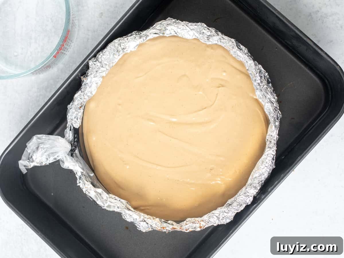 Decadent Biscoff Cheesecake Recipe with Crunchy Cookie Crust 7 Unbaked cheesecake in a water bath