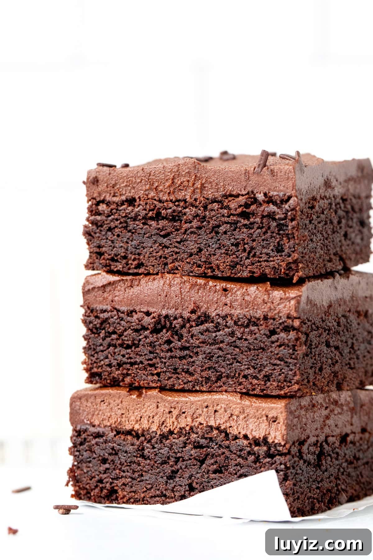 Chocolate Sugar Cookie Bars Recipe with Gooey Chocolate Chips 6 Three chocolate sugar cookie bars with chocolate frosting, stacked on top of each other