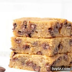 Banana Chocolate Chip Dessert Bars — Moist Baked Banana Squares 8 Three banana blondies with chocolate chips, stacked on top of one another
