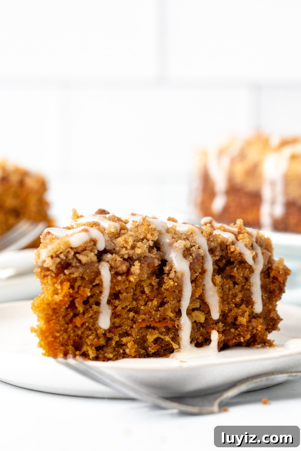 Moist Carrot Coffee Cake with Cream Cheese Glaze 2 Slice of carrot cake coffee cake with drizzle of glaze on top