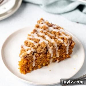 Moist Carrot Coffee Cake with Cream Cheese Glaze 9 Slice of carrot cake with crumb topping and a drizzle of glaze