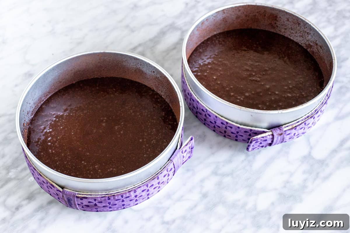 Decadent Chocolate Layer Cake Recipe with Moist Cocoa Frosting 4 two 8-inch cake pans with filled with cake batter.