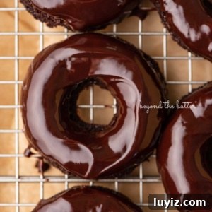 Homemade Baked Chocolate Donuts Recipe for Perfect Texture 13 Homemade baked chocolate donuts topped with chocolate ganache glaze on a wire cooling rack.