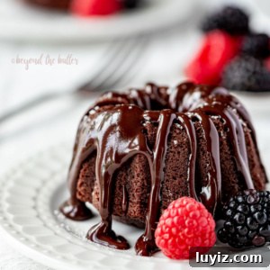 Mini Chocolate Bundt Pound Cakes — Perfect Bite-Sized Recipe 11 Small dessert plate with mini bundt chocolate pound cake drizzled with chocolate ganache and bowl of berries