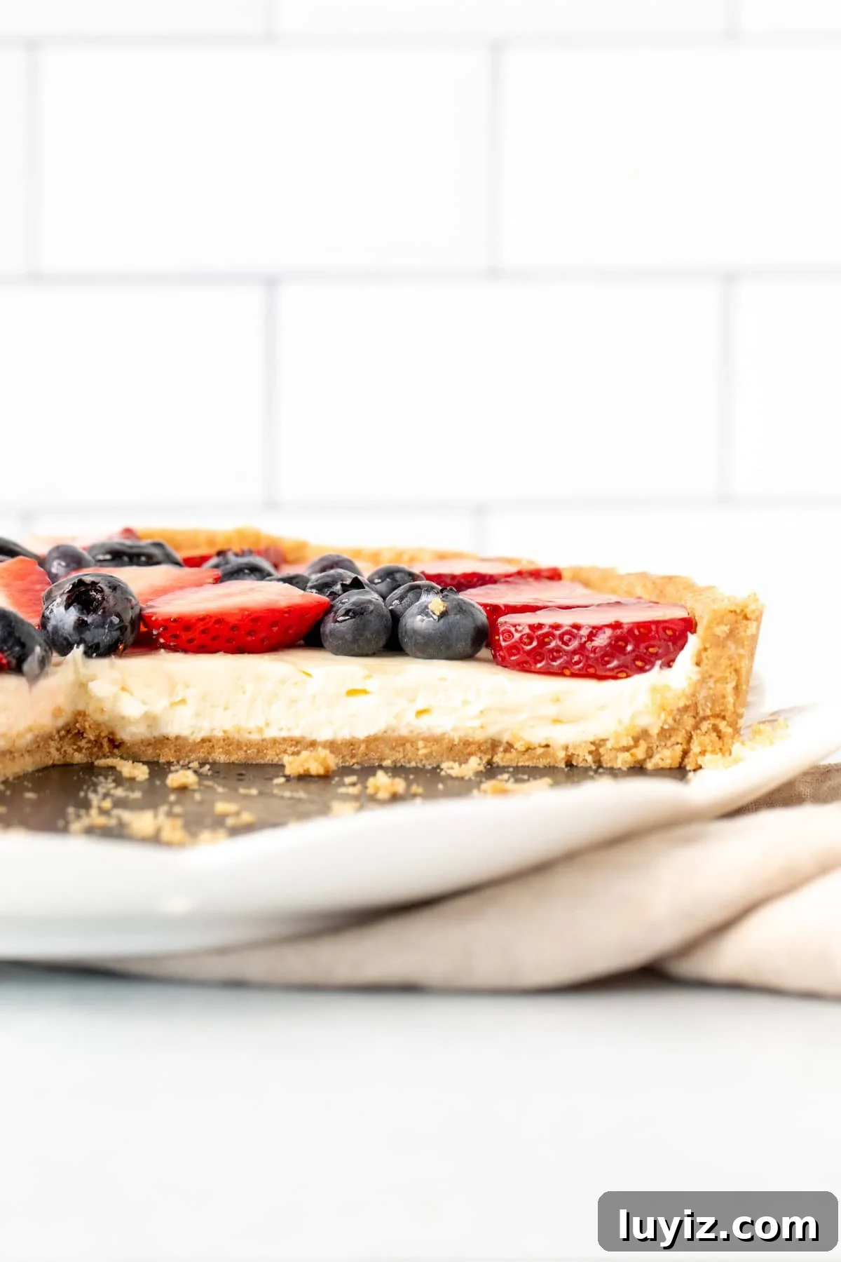 No-Bake Fresh Fruit Tart Recipe for Summer Parties 9 simple fruit tart with cream cheese filling and fruit on top on a plate