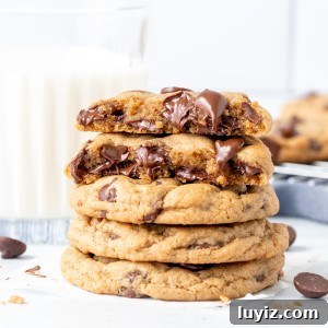 Cream Cheese Chocolate Chip Cookie Recipe for Extra Chewy Cookies 8 Stack of cream cheese chocolate chip cookies with top cookie broken in half.