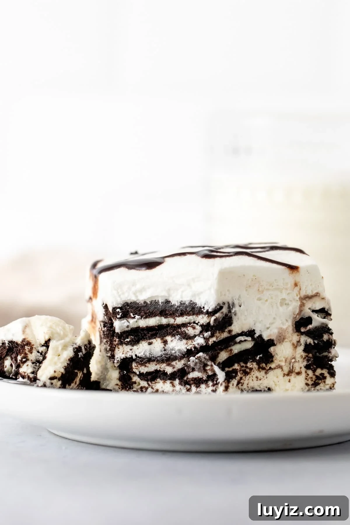 No-Bake Oreo Cheesecake Icebox Cake Recipe 3 Slice of layered cookies and cream icebox cake with a bite taken out