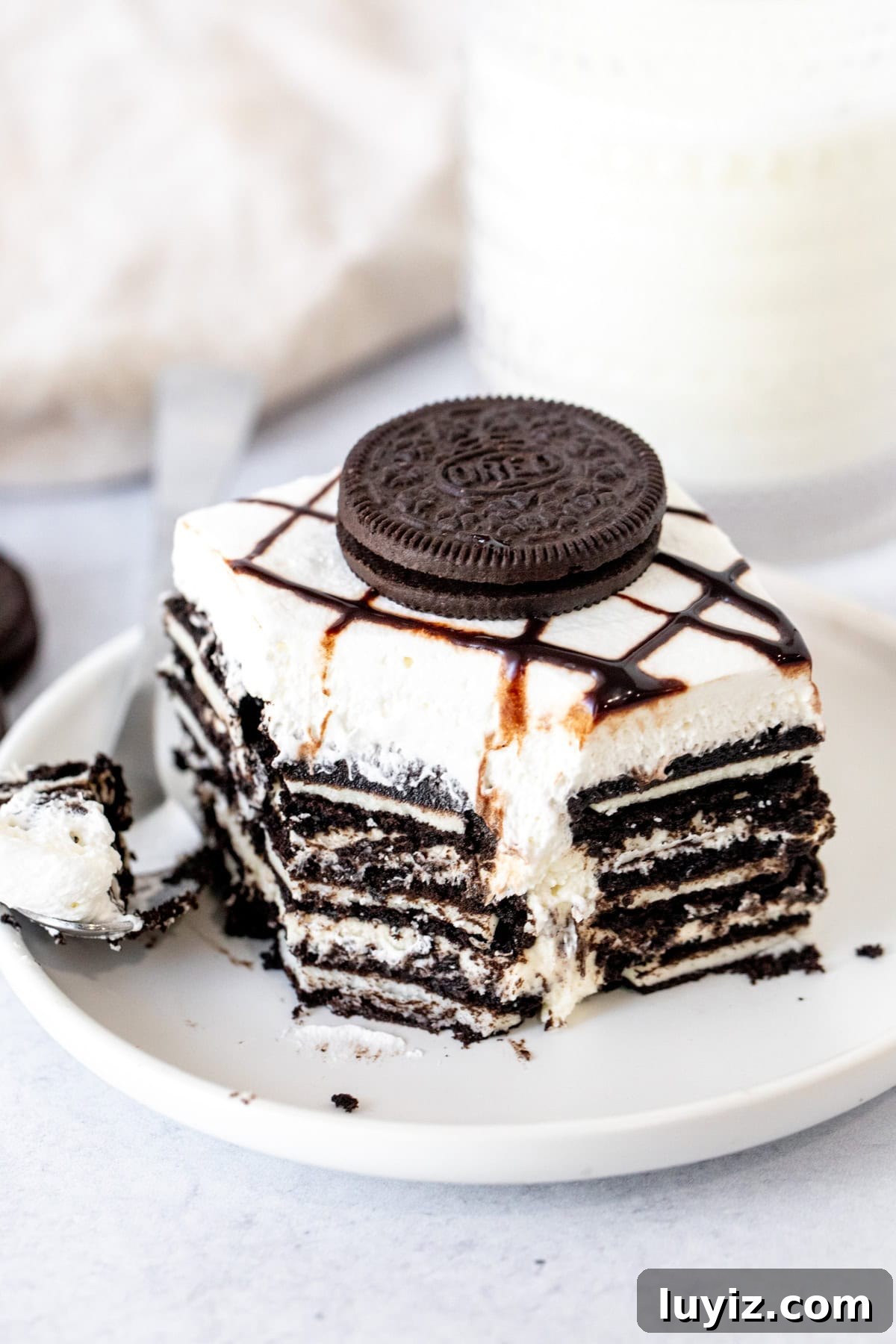 No-Bake Oreo Cheesecake Icebox Cake Recipe 7 Slice of layered Oreo icebox cake with a bite taken out