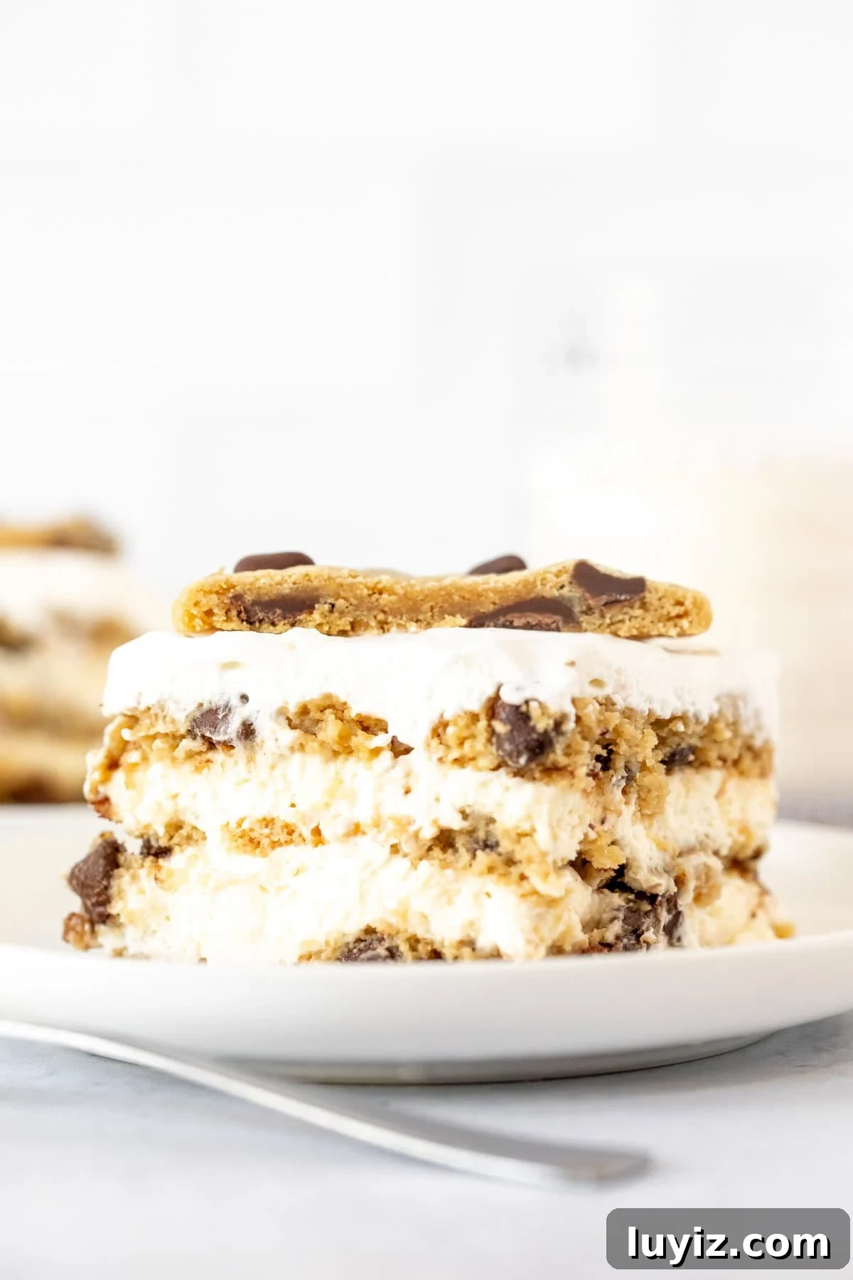 No-Bake Chocolate Chip Cookie Icebox Cake Recipe 2 Slice of chocolate chip cookie icebox cake with half a cookie on top