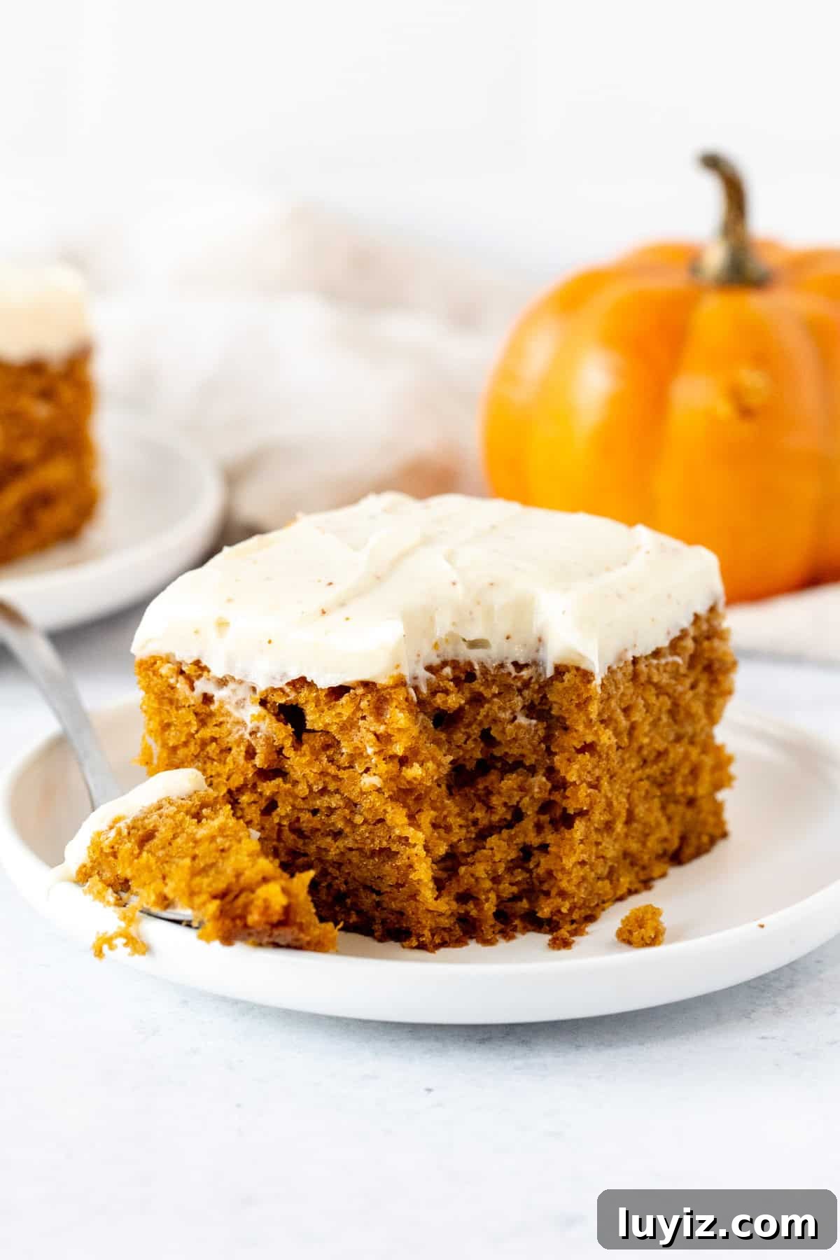 Ultimate Moist Pumpkin Cake Recipe for Fall Baking 10 Pumpkin cake with a bite taken from a fork