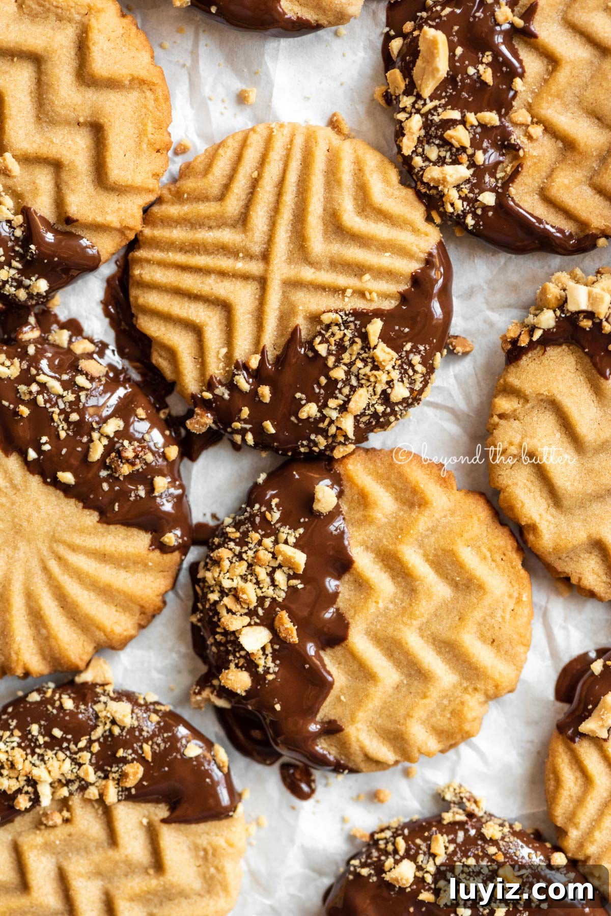 Chocolate-Dipped Peanut Butter Cookies with Crisp Edges 5 Baking sheet with randomly placed chocolate dipped peanut butter cookies | All Images © Beyond the Butter®