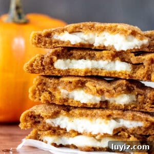 Pumpkin Cheesecake Cookie Recipe — Soft Pumpkin Cookies with Creamy Filling 9 Stack of pumpkin cheesecake cookie halves