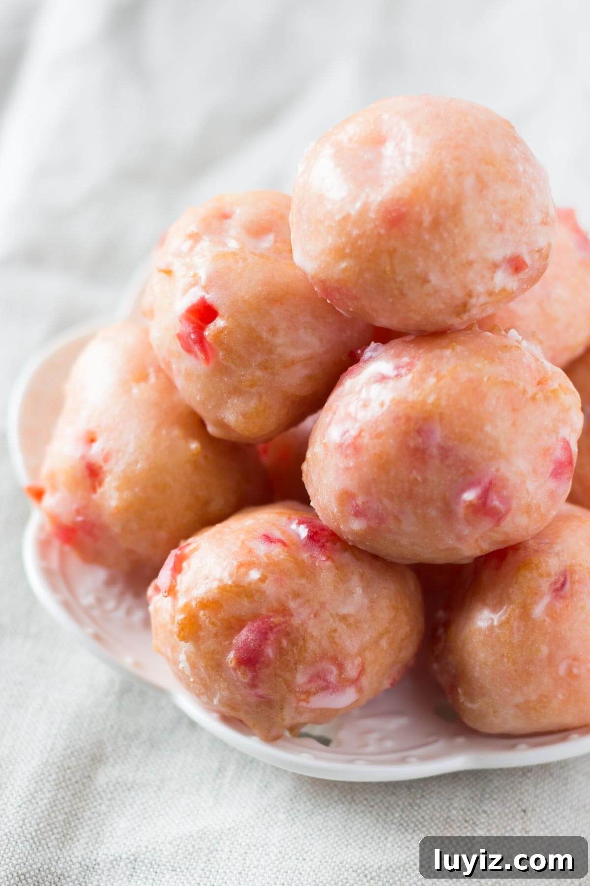 Cherry Doughnut Holes made from scratch! Delicious cake doughnut texture, perfectly pink in color & dripped in sweet glaze. You NEED to make these!