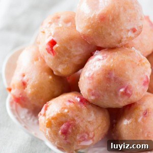 Cherry Doughnut Holes made from scratch! Delicious cake doughnut texture, perfectly pink in color & dripped in sweet glaze. So delicious & so easy!