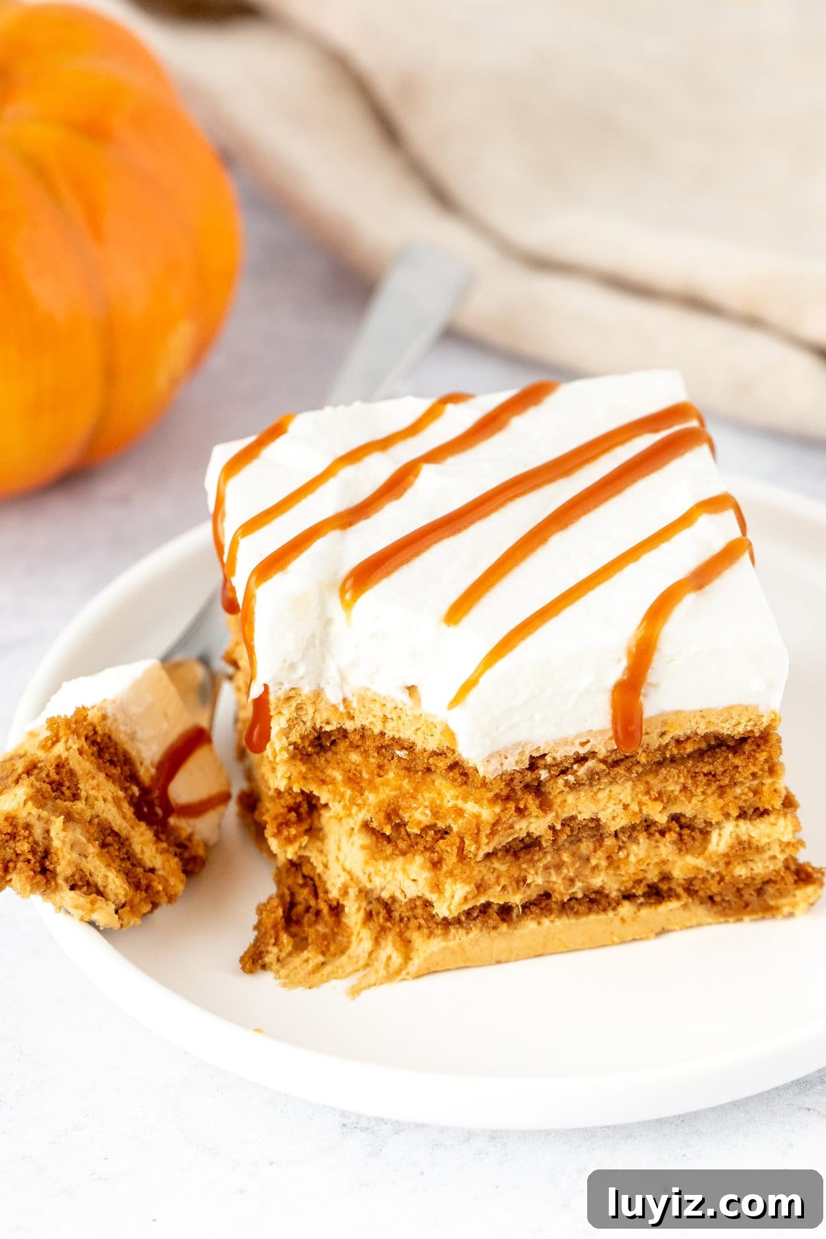 No-Bake Pumpkin Icebox Cake Recipe for Fall Desserts 3 Pumpkin icebox cake with layers of cookies and creamy no bake pumpkin cheesecake filling with whipped cream and caramel on top