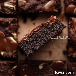 Decadent Double Chocolate Mint Brownies Recipe 13 Double chocolate mint brownies on brown parchment paper background with the center brownie on its side.