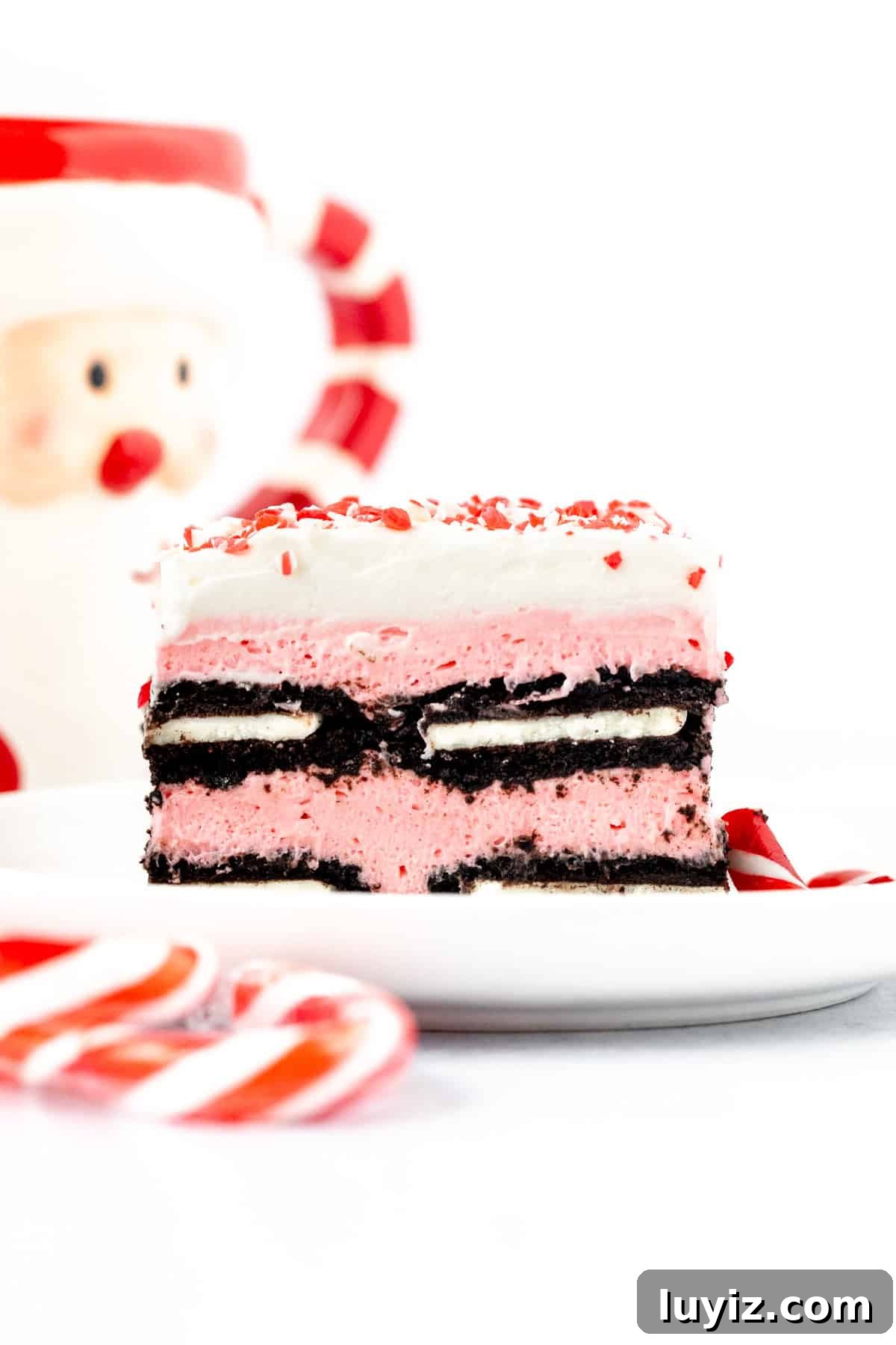 Peppermint Candy Cane Icebox Cake Recipe for the Holidays 6 Slice of candy cane icebox cake, with layers of pink no bake cheesecake filling and Oreo cookies, topped with whipped cream and crushed candy canes