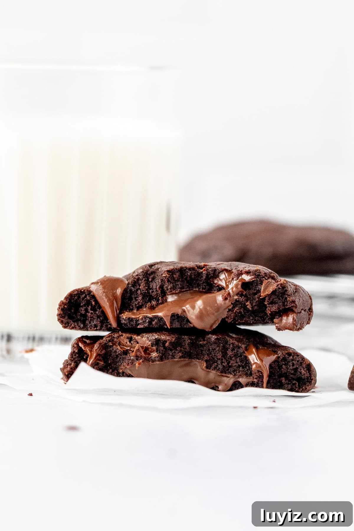 Nutella-Filled Double Chocolate Cookies 3 Nutella stuffed cookie, broken in half with glass of milk