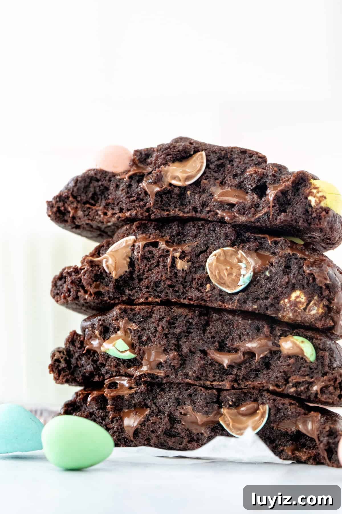 Mini Egg Chocolate Cookie Recipe: Soft Cookies with Candy Eggs 3 Chocolate cookies with Easter Candies, broken in half and stacked on top of one another