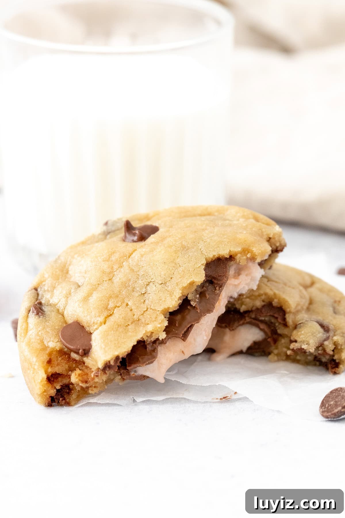 Cream Egg-Stuffed Cookies: Gooey Chocolate and Cream Filling Recipe 5 Cream Egg chocolate chip cookie, broken in half with glass of milk