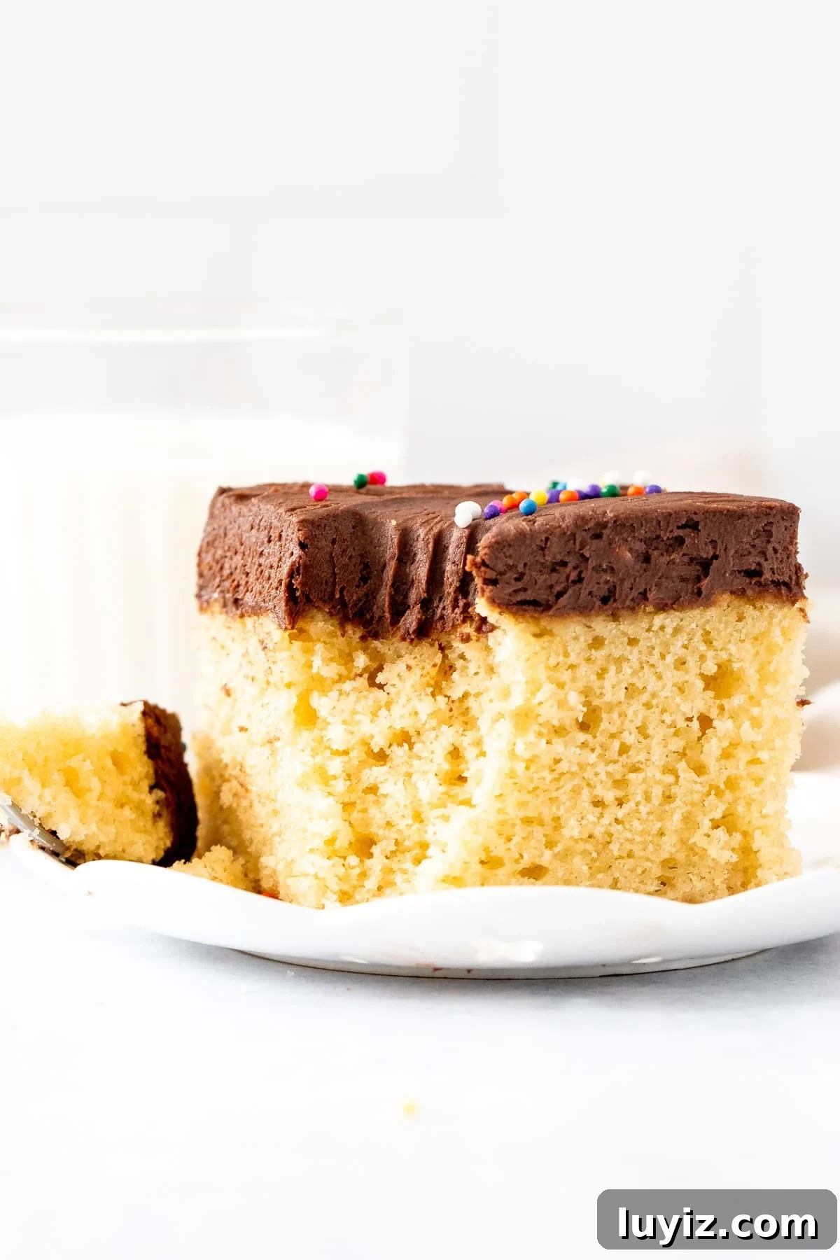 Moist Yellow Sheet Cake with Decadent Chocolate Frosting 10 Slice of golden cake with chocolate frosting, with a bite taken out