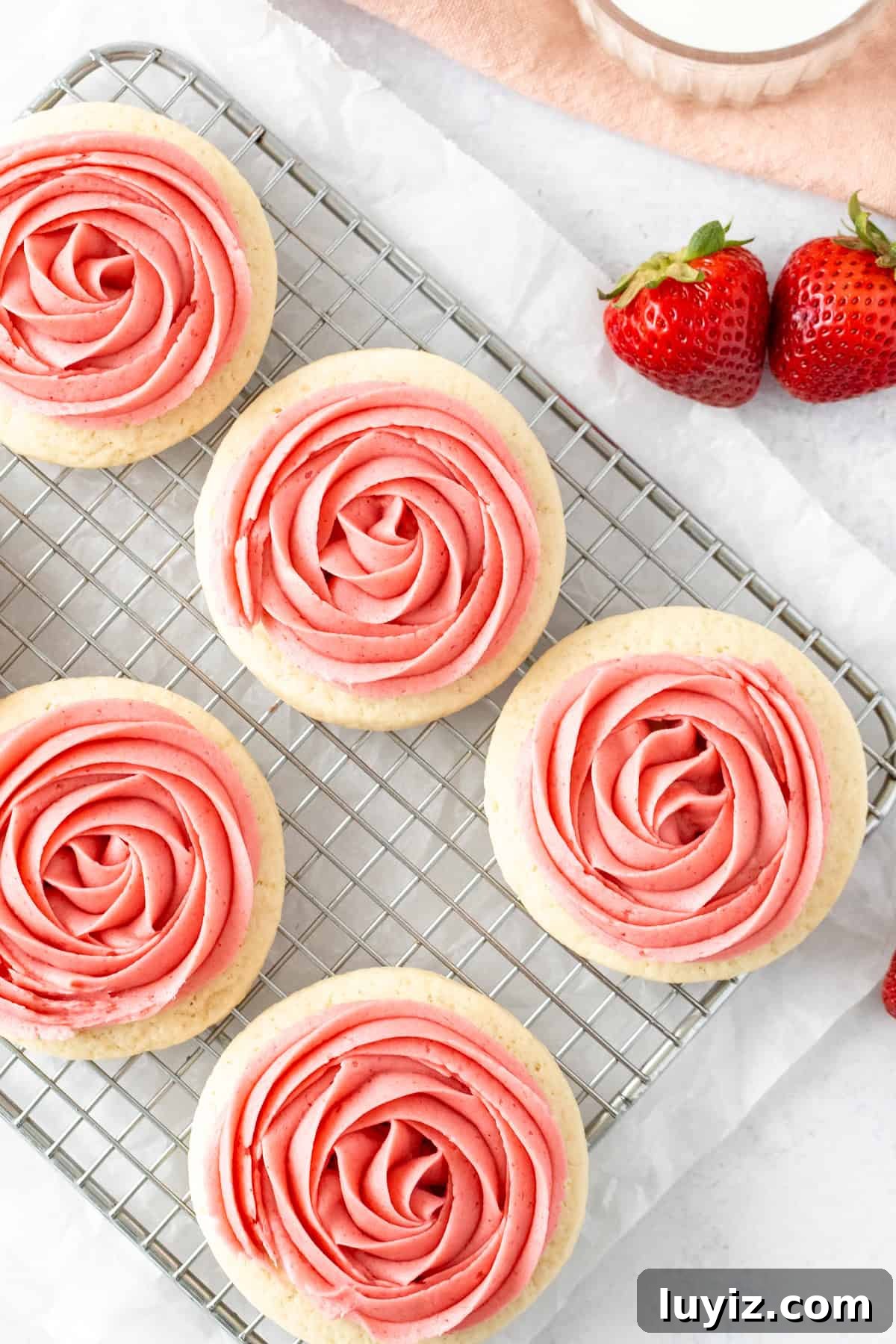 Strawberry Frosted Sugar Cookies Recipe — Soft & Chewy Cookies 4 Sugar cookies with strawberry frosting on a cooling rack