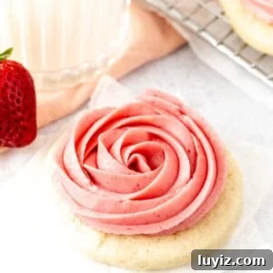 Sugar cookie topped with strawberry frosting piped into a rosette shape