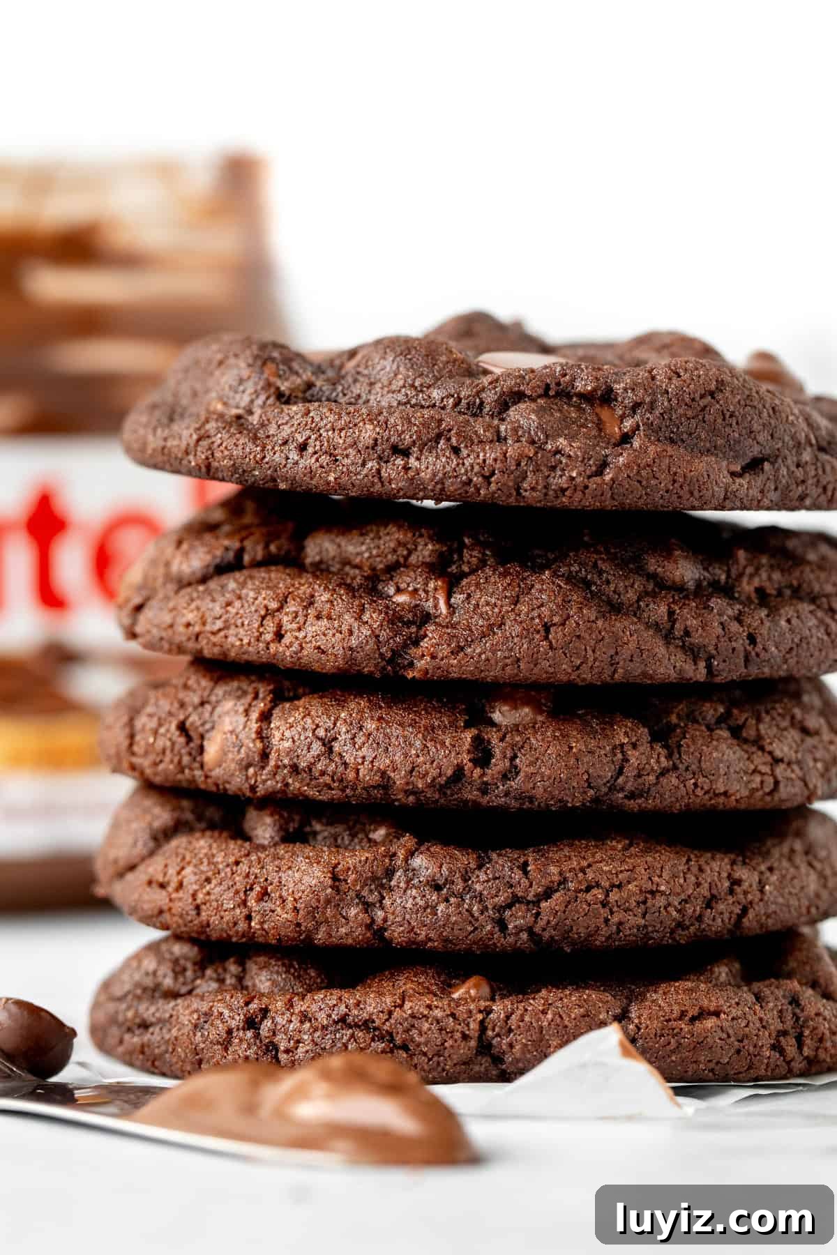 Chewy Nutella Cookies Recipe: Rich, Melt-in-Your-Mouth Treats 2 Stack of Nutella chocolate cookies with jar of Nutella in the background