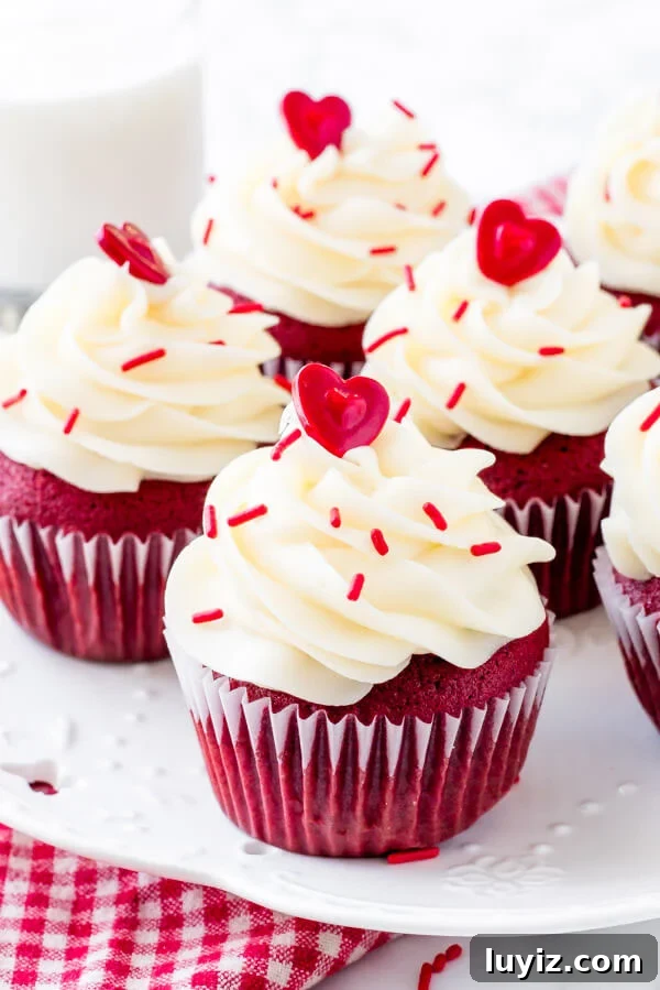 Decadent Red Velvet Cupcakes with Cream Cheese Frosting 3 A plate of red velvet cupcakes with cream cheese frosting & sprinkles