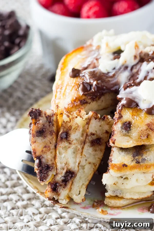 Fluffy Chocolate Chip Pancakes with Vanilla Syrup Recipe 4 A close up shot of bite of chocolate chip pancakes on a fork.