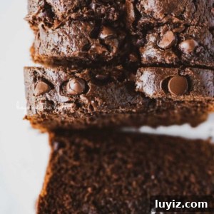 One-Bowl Chocolate Zucchini Quick Bread Recipe 15 Sliced chocolate zucchini bread on white background.