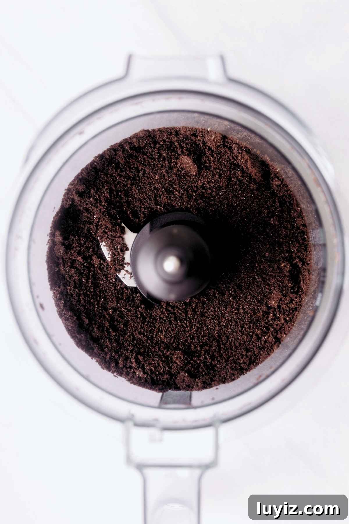Decadent Chocolate Cake with Oreo Buttercream Frosting 14 Chocolate sandwich cookie crumbs in a food processor with the lid off.