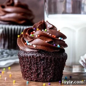 Chocolate cupcake with paper removed beside glass of milk