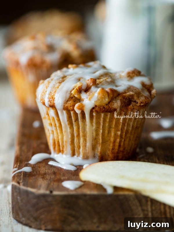 Apple Cider Whoopie Pies with Cinnamon Buttercream Filling 9 Warm apple cinnamon streusel muffins on a wood cutting board with slices of apples and vanilla glaze.