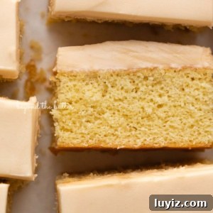 Butterscotch Krimpet Sheet Cake Recipe — Moist Retro Dessert 17 Rectangular slices of butterscotch krimpets placed on a parchment paper lined background with center slice on its side.