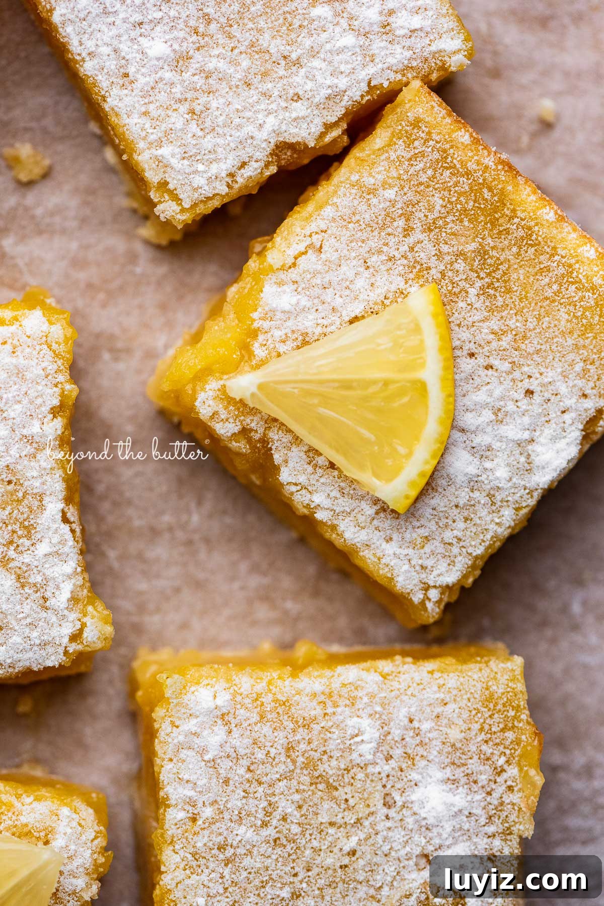 Simple Homemade Lemon Bars – Zesty Citrus Dessert Recipe 3 Tart and tangy lemon bars on parchment paper | © Beyond the Butter®