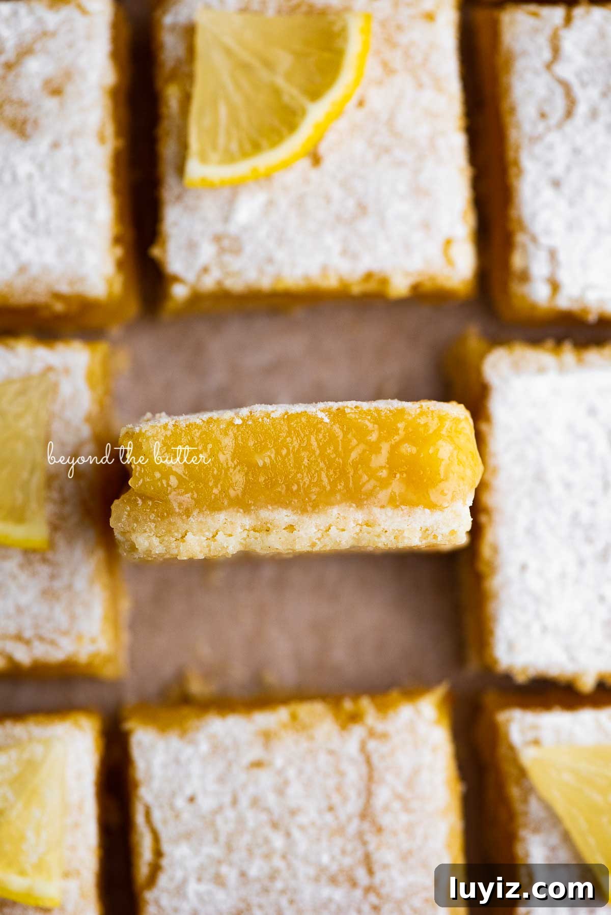 Simple Homemade Lemon Bars – Zesty Citrus Dessert Recipe 4 Sliced super easy lemon bars on parchment paper | © Beyond the Butter®