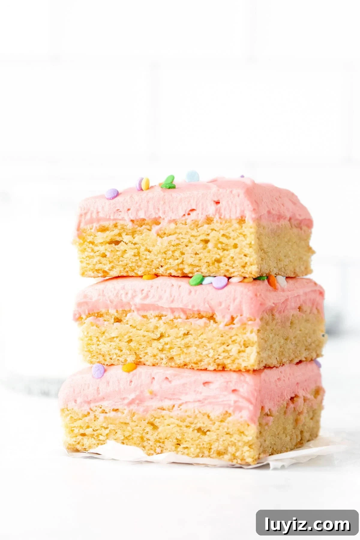 Chewy Frosted Sugar Cookie Bars with Vanilla Buttercream 2 Stack of three sugar cookie bars decorated with pink frosting