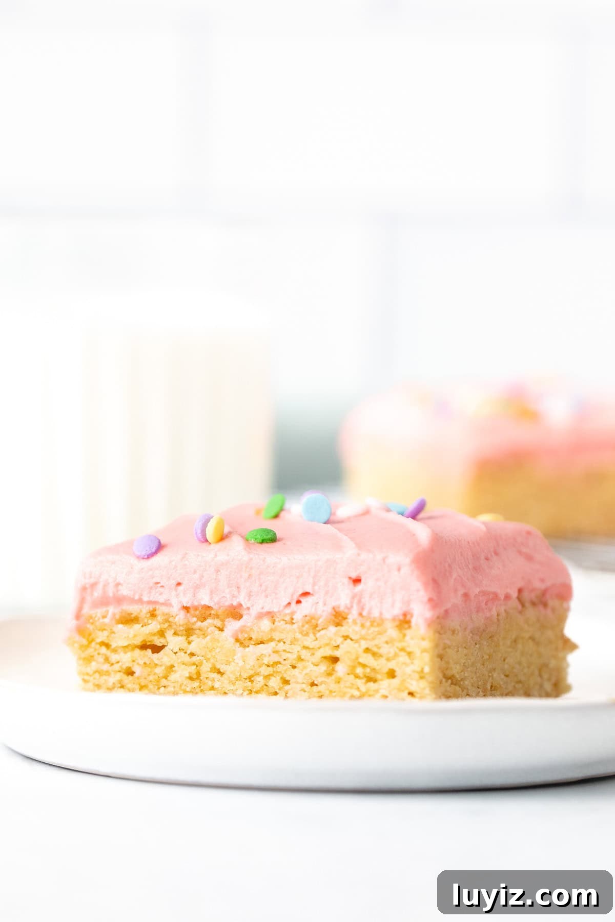 Chewy Frosted Sugar Cookie Bars with Vanilla Buttercream 3 Frosted sugar cookie bars on plate with glass of milk