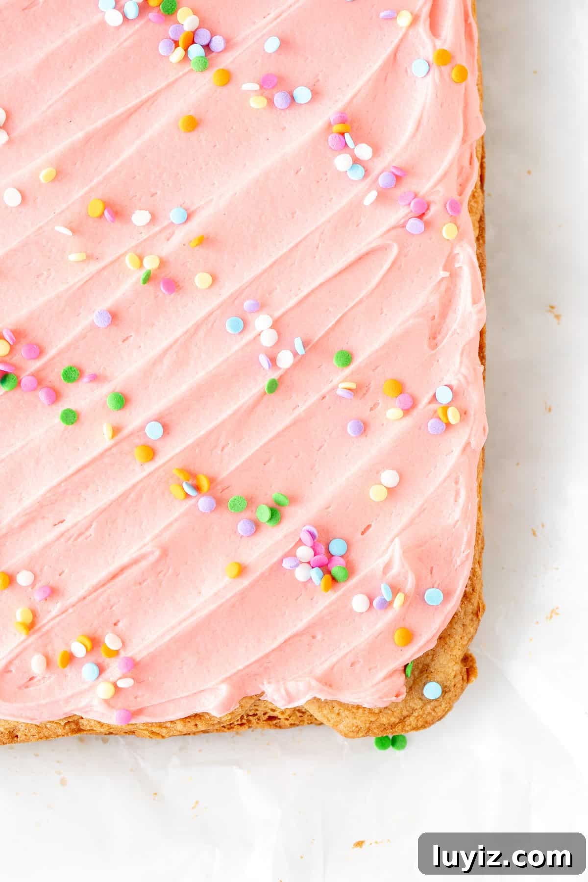 Chewy Frosted Sugar Cookie Bars with Vanilla Buttercream 6 pan of sugar cookie bars topped with pink frosting and sprinkles