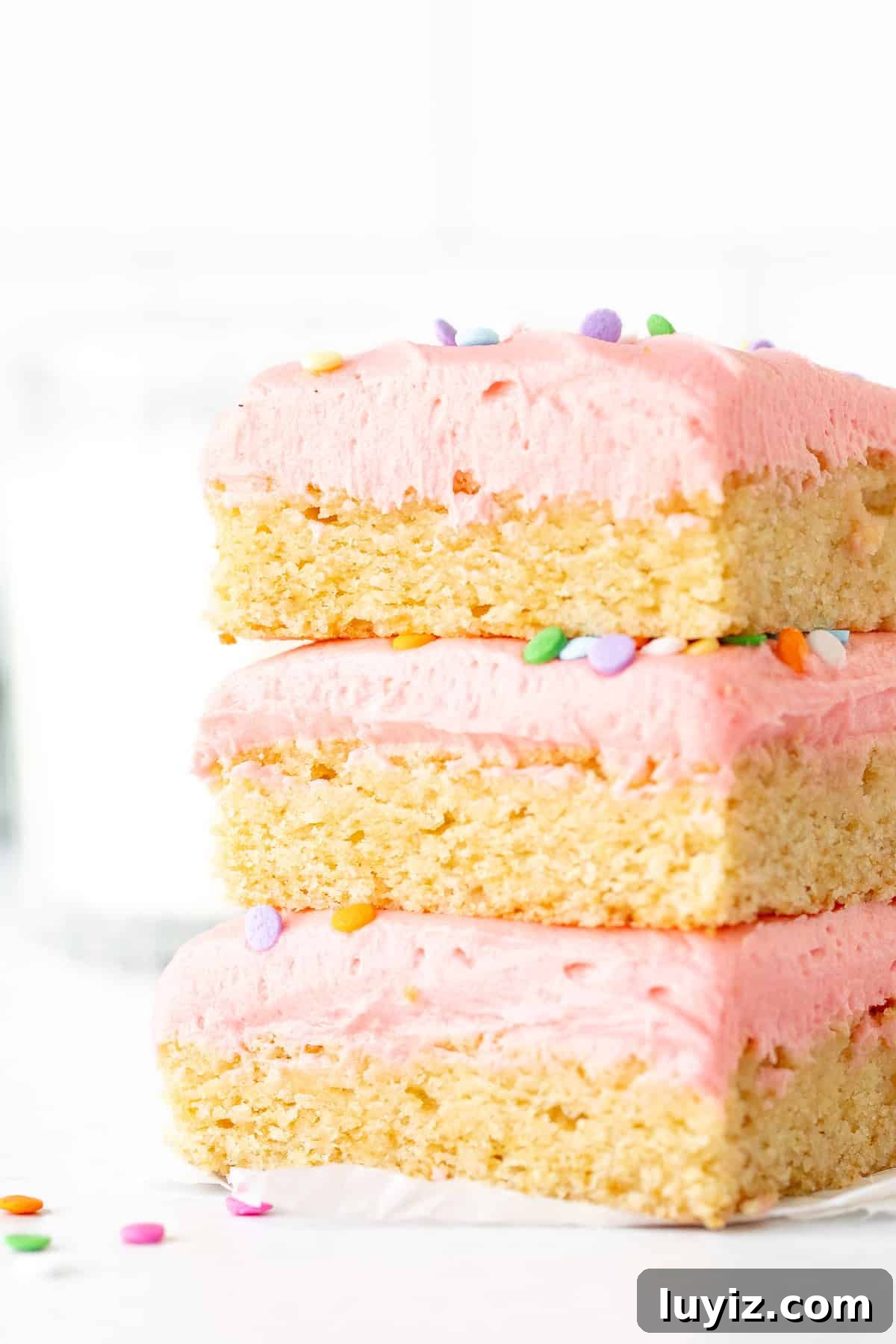Chewy Frosted Sugar Cookie Bars with Vanilla Buttercream 7 Three frosted sugar cookie bars, one on top of each other