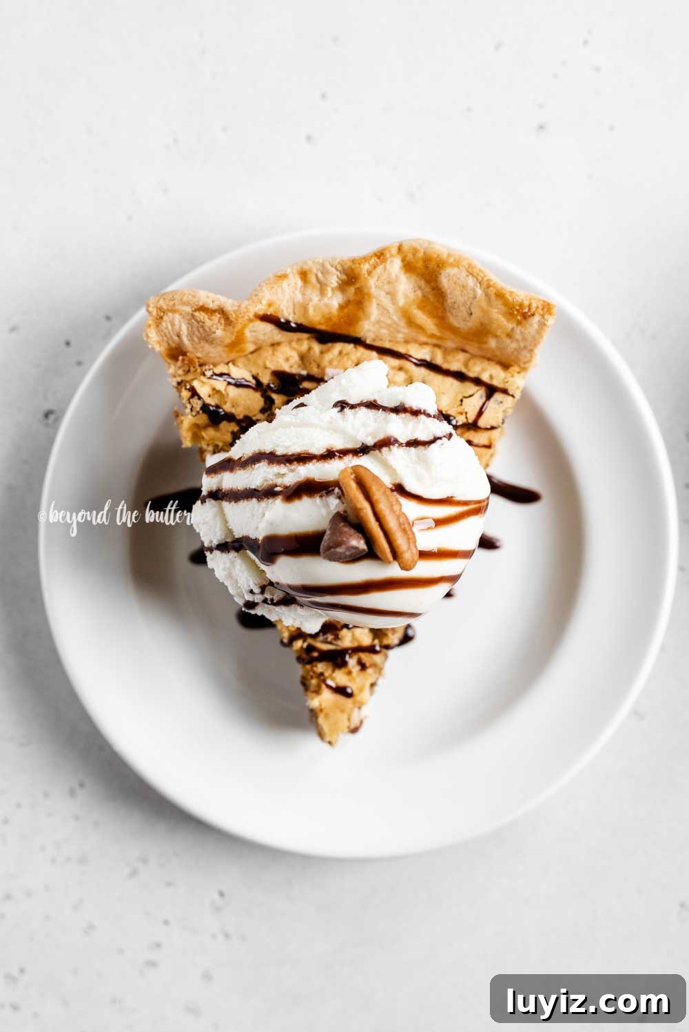 Ultimate Chocolate Chip Pie Recipe: Gooey, Crispy, and Irresistible 5 Overhead image of one slice of chocolate chip pie with a scoop of vanilla ice cream on top drizzled with chocolate syrup