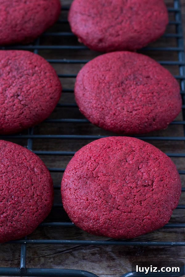 Red Velvet Cookies with Cream Cheese Frosting Recipe 4 Freshly baked, soft red velvet cookies on a cooling rack.