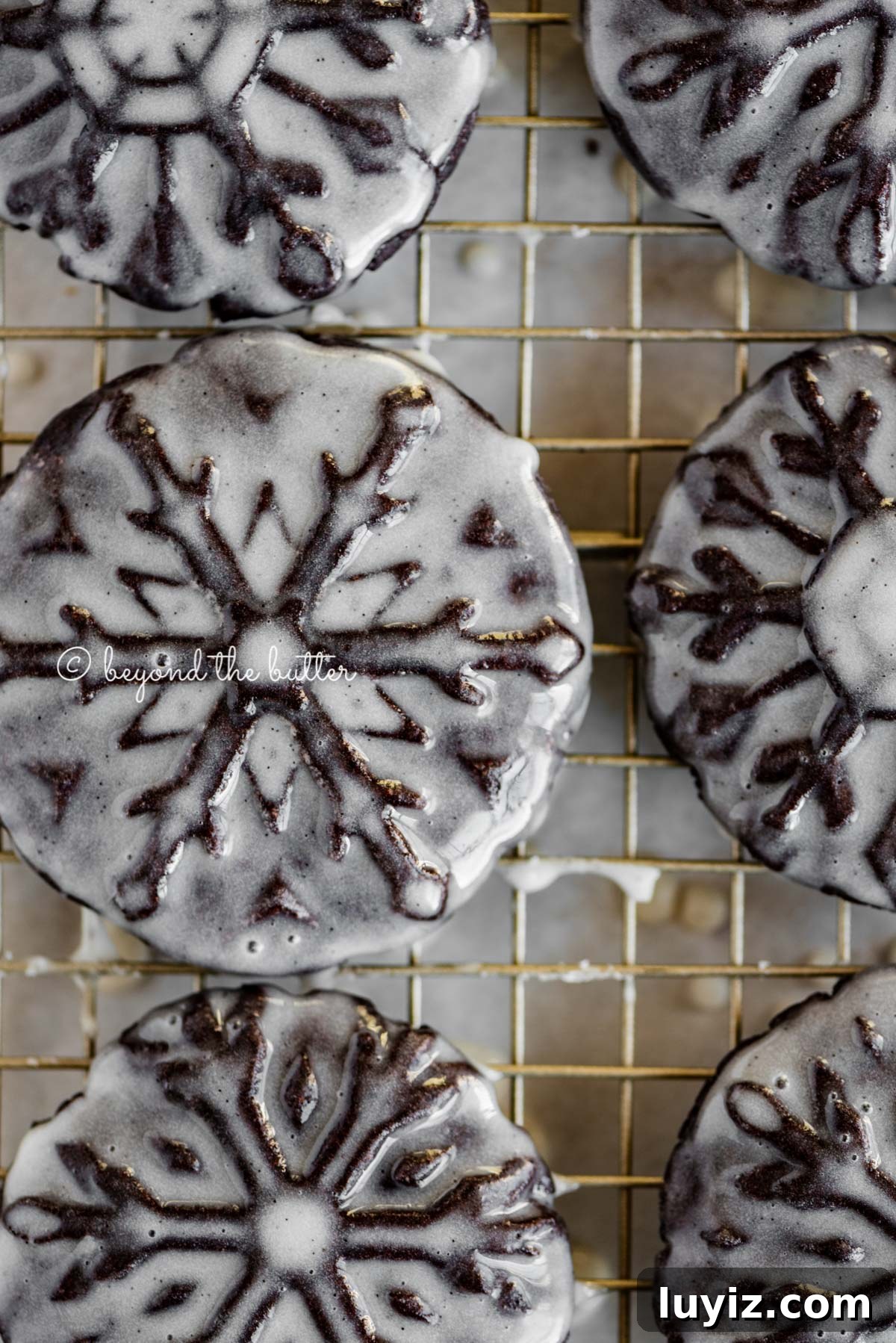 Oreo Snowflake Cookies Recipe: Holiday Sandwich Cookies 6 Overhead closeup image of homemade oreo snowflake cookies on a wire cooling rack | All Images © Beyond the Butter®