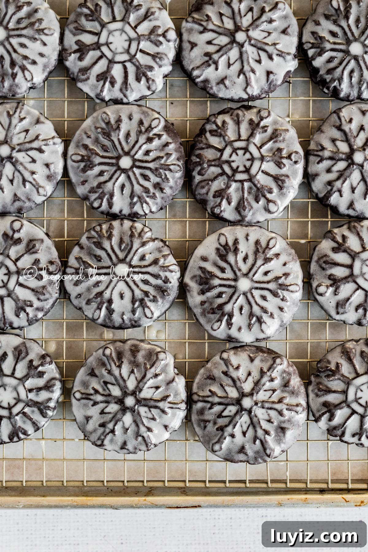 Oreo Snowflake Cookies Recipe: Holiday Sandwich Cookies 7 Overhead image of homemade oreo snowflake cookies on a wire cooling rack | All Images © Beyond the Butter®
